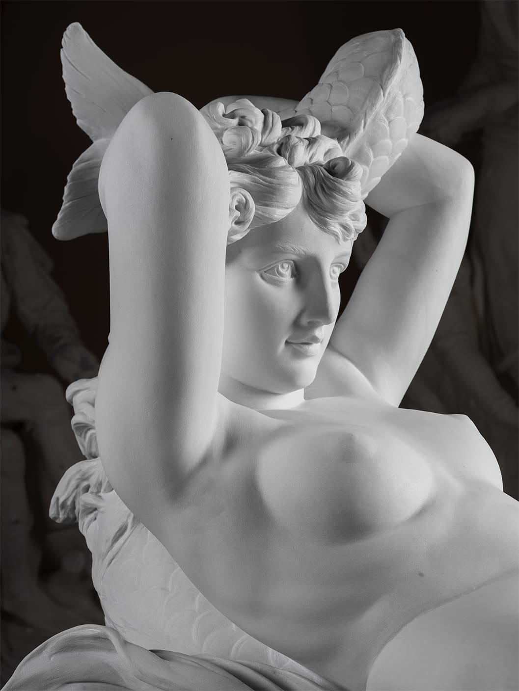 White marble statue of a woman with wings in her hair, reclining with her arms raised behind her head, detailed facial expression, classical style sculpture.